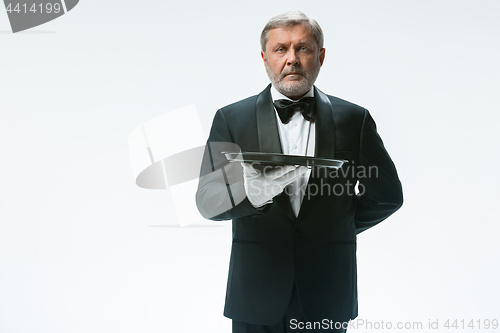 Image of Senior waiter holding tray