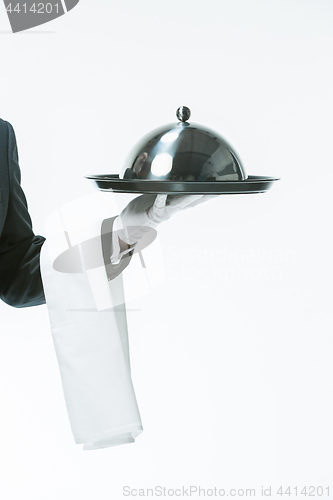 Image of Close up waiter hand with tray and metal cloche lid cover