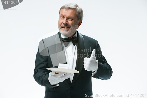 Image of Senior waiter holding tray