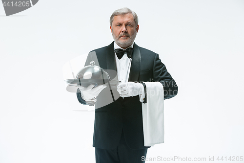 Image of Senior waiter holding tray