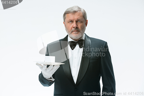 Image of Senior waiter holding tray