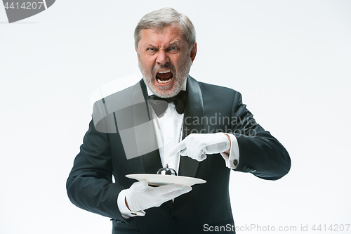 Image of Senior waiter holding bell