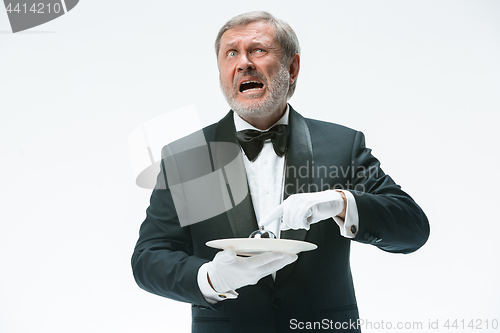 Image of Senior waiter holding bell