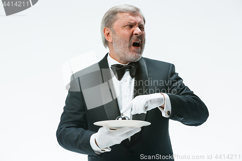 Image of Senior waiter holding bell