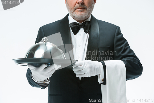 Image of Senior waiter holding tray