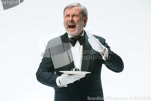 Image of Senior waiter holding bell