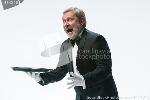 Image of Senior waiter holding tray