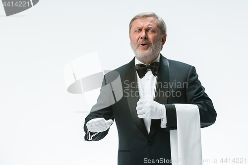 Image of Senior waiter holding white towel