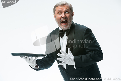 Image of Senior waiter holding tray