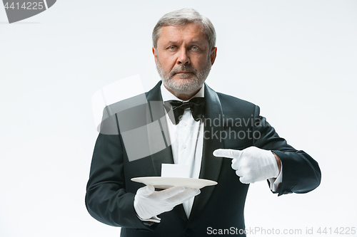 Image of Senior waiter holding tray