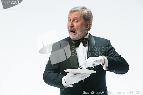 Image of Senior waiter holding bell