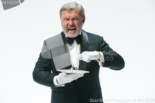 Image of Senior waiter holding bell