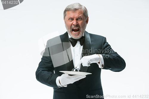 Image of Senior waiter holding bell