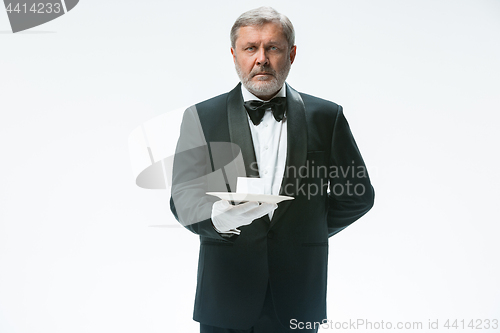 Image of Senior waiter holding tray