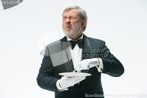 Image of Senior waiter holding bell