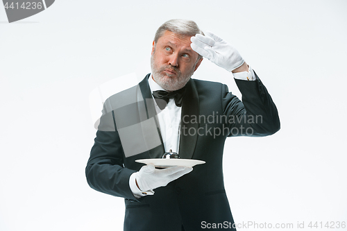 Image of Senior waiter holding bell