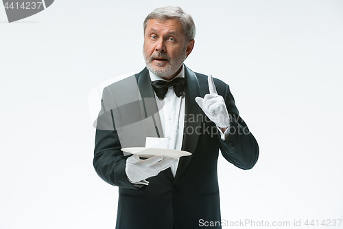 Image of Senior waiter holding tray