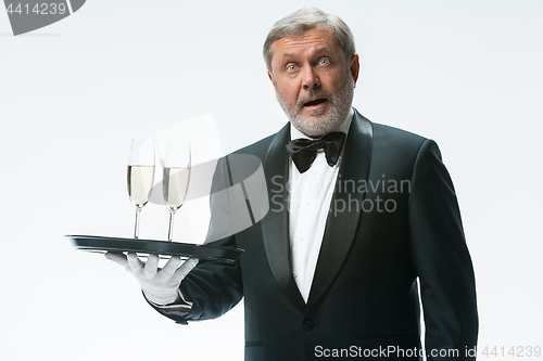 Image of professional waiter in uniform is serving wine