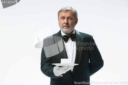 Image of Senior waiter holding tray