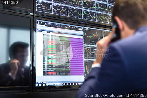 Image of Stock trader looking at market data on computer screens.