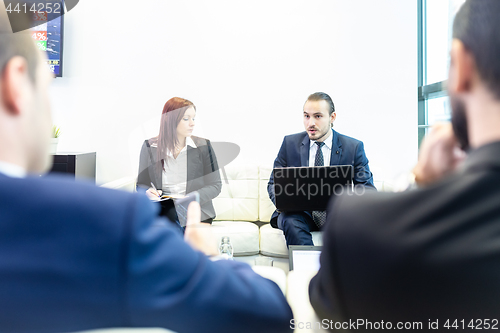 Image of Business people sitting at working meeting in modern corporate office.