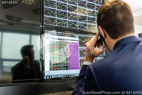 Image of Stock trader looking at market data on computer screens.