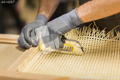 Image of assembler with staple gun making furniture