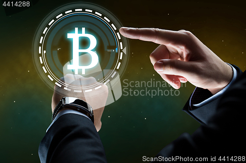 Image of businessman with smart watch and bitcoin hologram