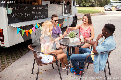 Image of friends clinking bottles with drinks at food truck