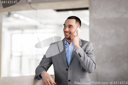 Image of businessman calling on smartphone at office