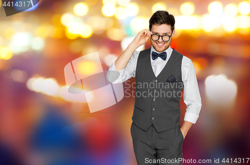 Image of man in suit with glasses over night city lights