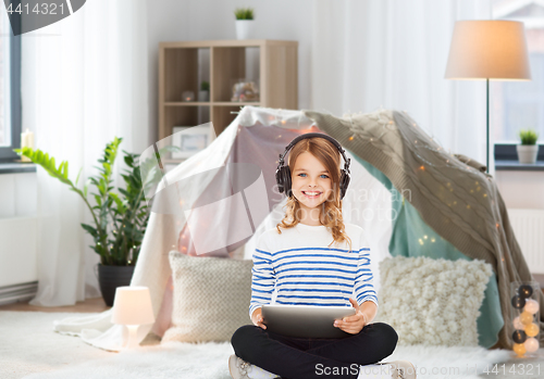 Image of girl with headphones and tablet pc at home