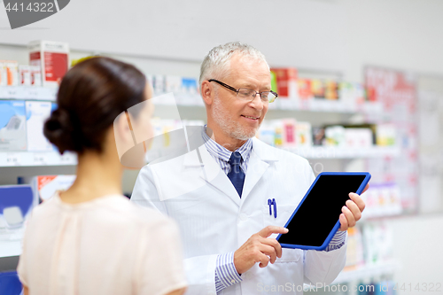 Image of apothecary and customer with tablet pc at pharmacy