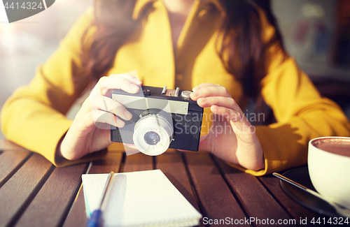Image of close up of woman with camera at city cafe