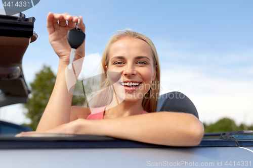 Image of happy young woman with convertible car key