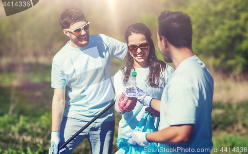 Image of volunteers with garbage bags cleaning park area