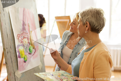 Image of women with brushes painting at art school