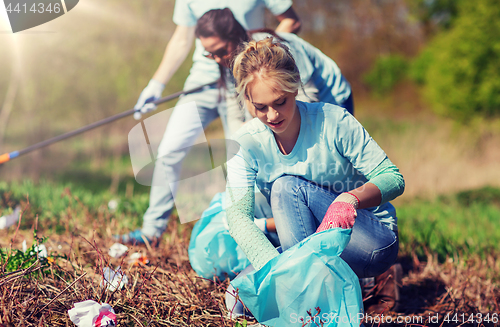 Image of volunteers with garbage bags cleaning park area