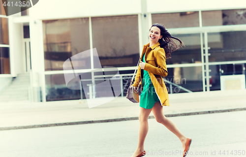 Image of happy young woman or teenage girl on city street