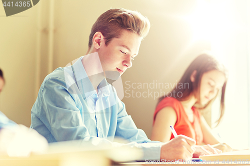 Image of group of students with books writing school test