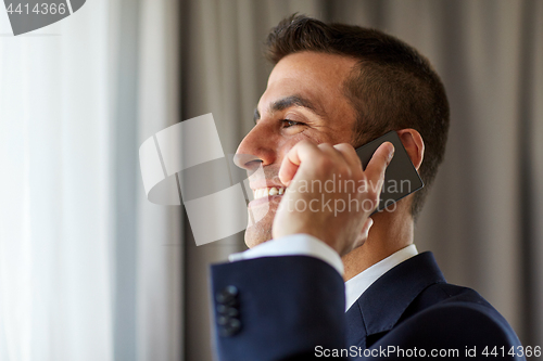 Image of businessman calling on smartphone at hotel room