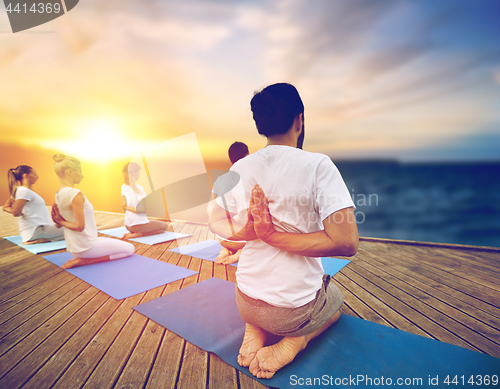 Image of group of people doing yoga outdoors