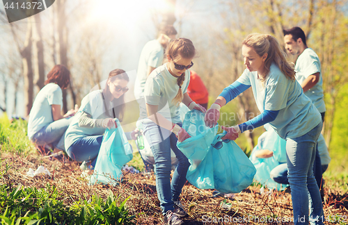 Image of volunteers with garbage bags cleaning park area