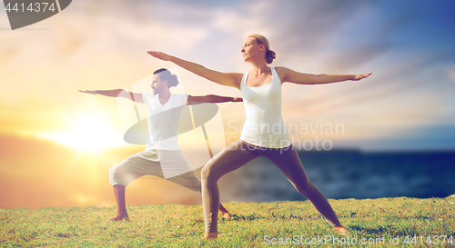 Image of couple making yoga warrior pose outdoors