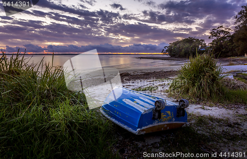 Image of The little blue rowboat on the shore