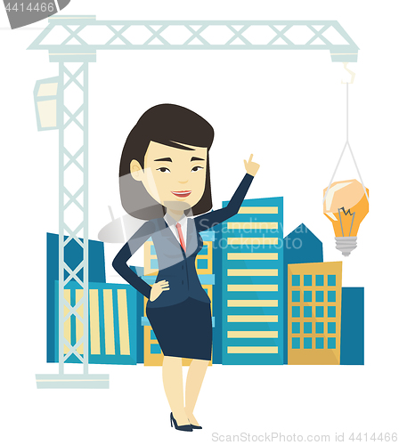 Image of Woman pointing at idea bulb hanging on crane.