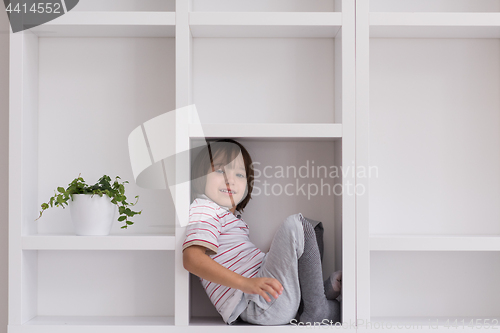 Image of young boy posing on a shelf