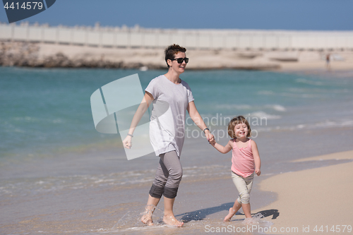 Image of mother and daughter running on the beach