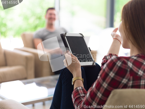 Image of couple relaxing at  home with tablet and laptop computers