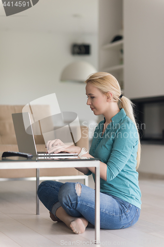 Image of young women using laptop computer on the floor